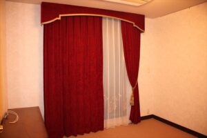 グレーのダマスク柄の壁紙とバーガンディ―の起毛したカーテンの組み合わせ